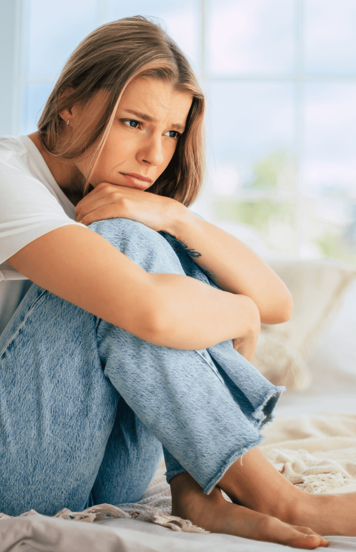 Woman sitting, looking thoughtful and concerned.