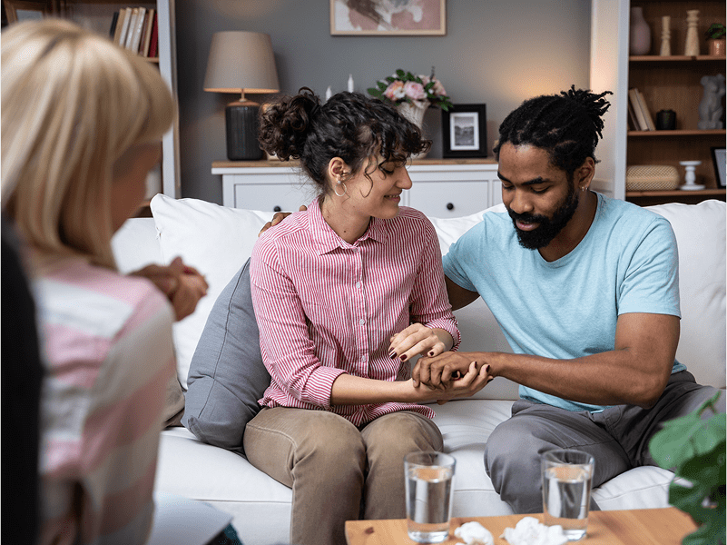 Couple holding hands in a therapy session.