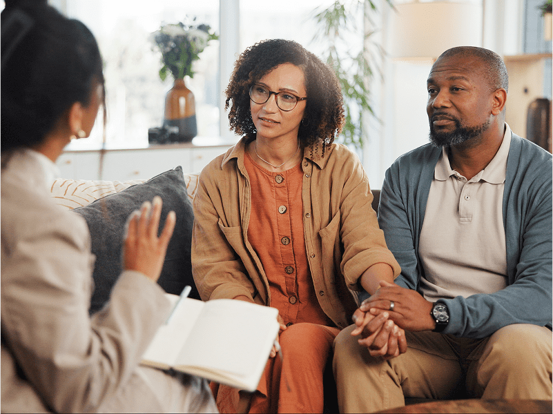 Couple holding hands during a therapy session.