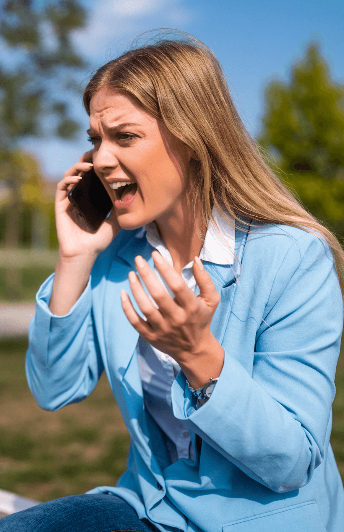 Woman frustrated while talking on phone outside.