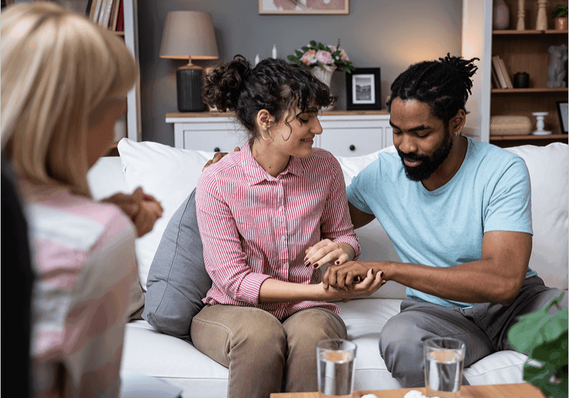 Couple holding hands in a therapy session.